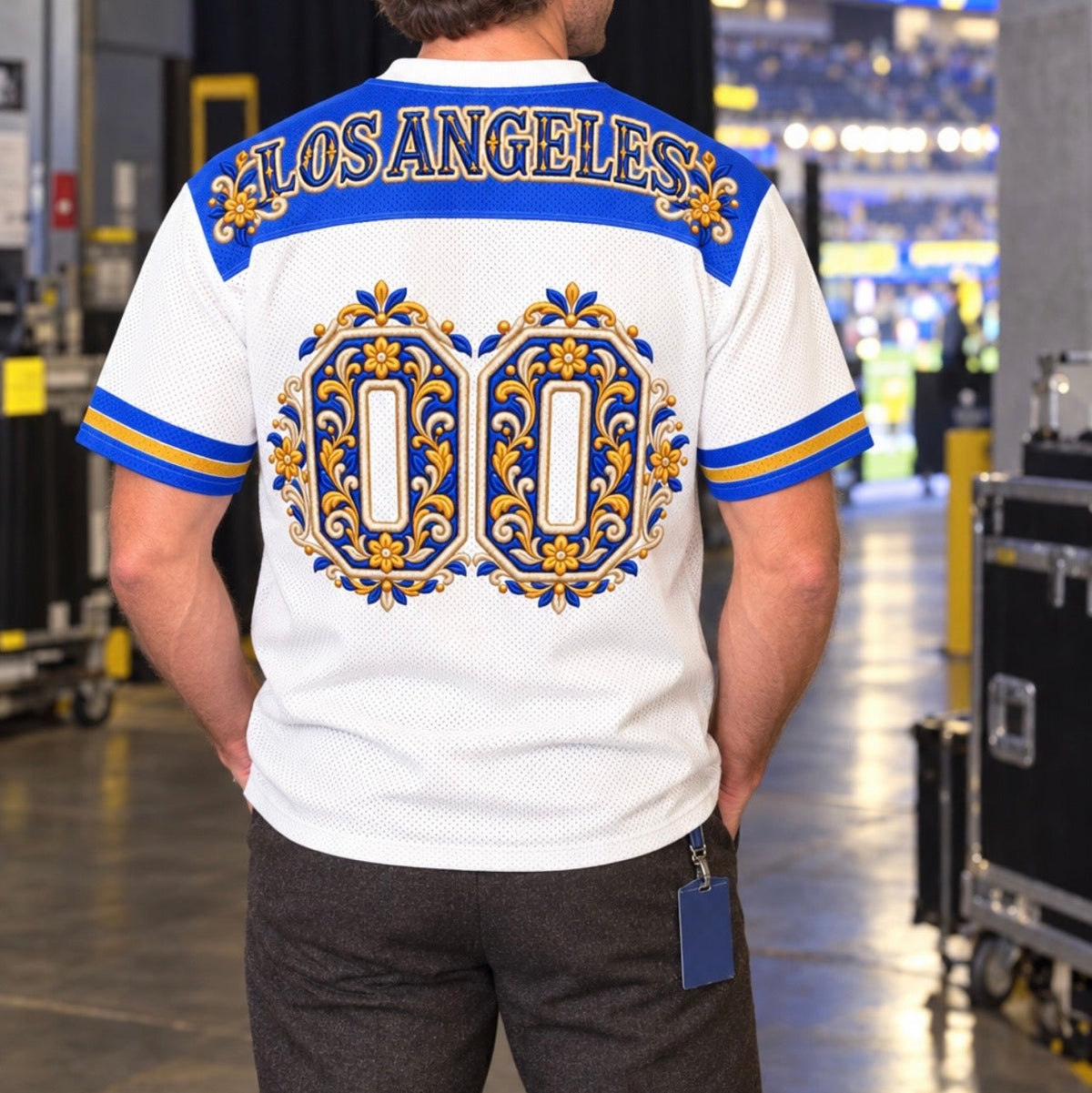 A man viewed from behind wearing a white Los Angeles Angels jersey shirt with a large gold and blue ornate '00' design on the back, standing in a stadium concourse.